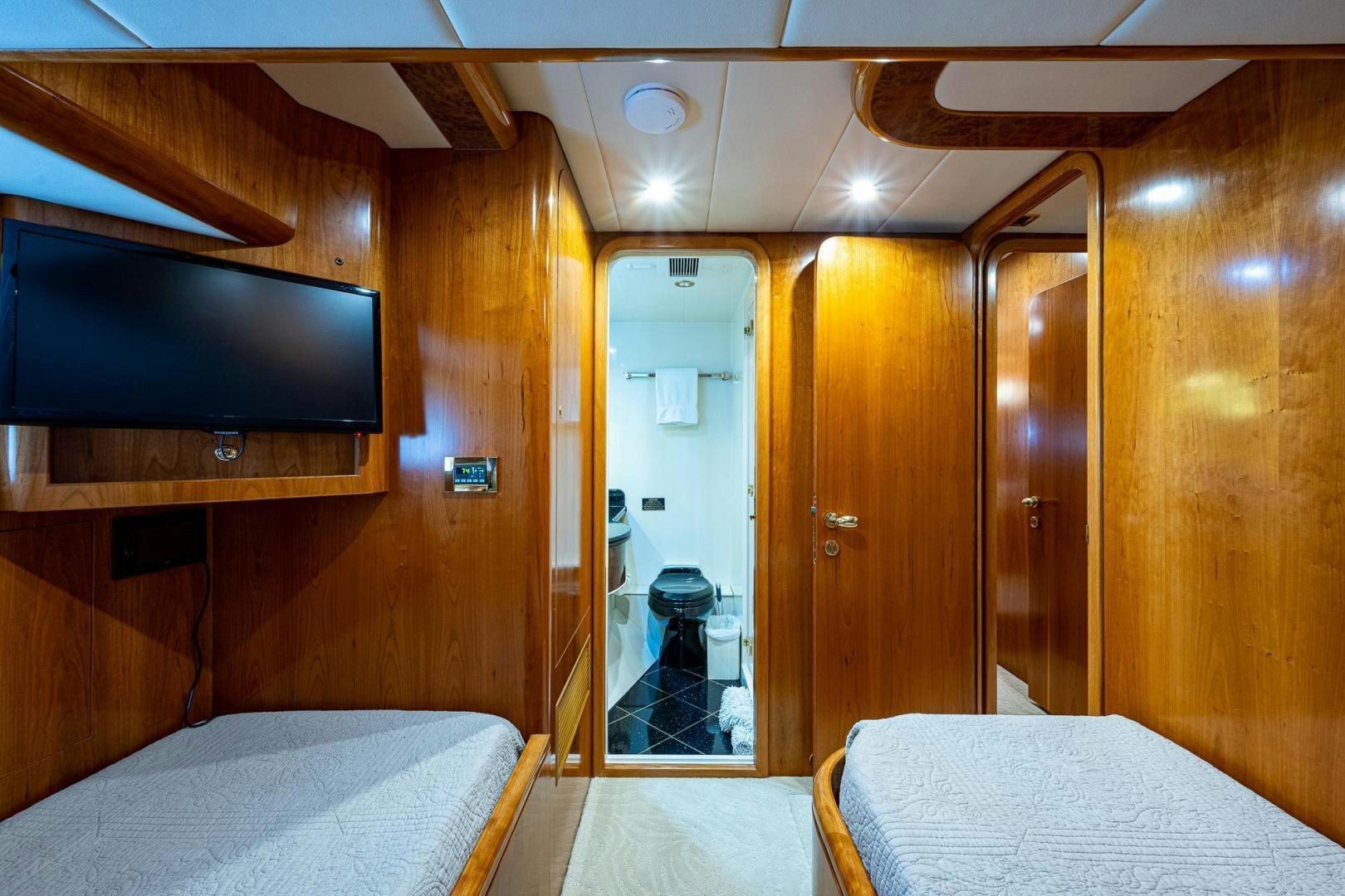 a room with a bed and a television aboard ODYSSEY Yacht for Sale