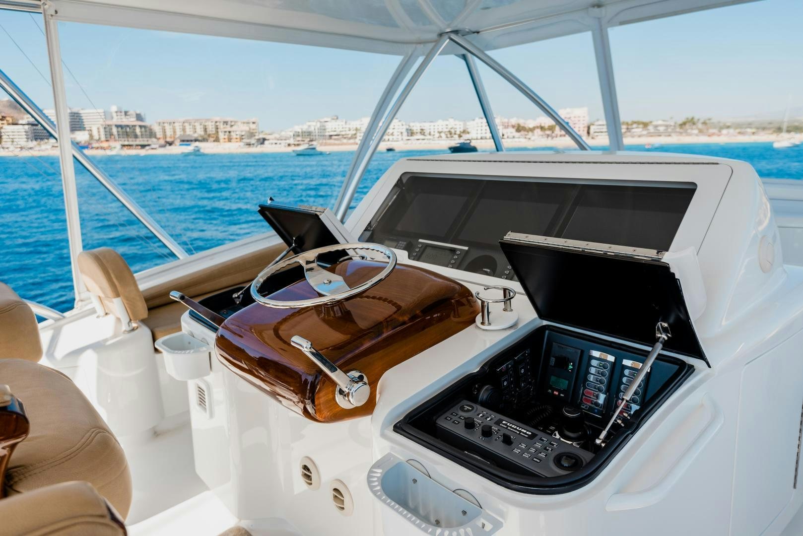 a boat with a steering wheel and a boat in the background aboard C STUDENT Yacht for Sale