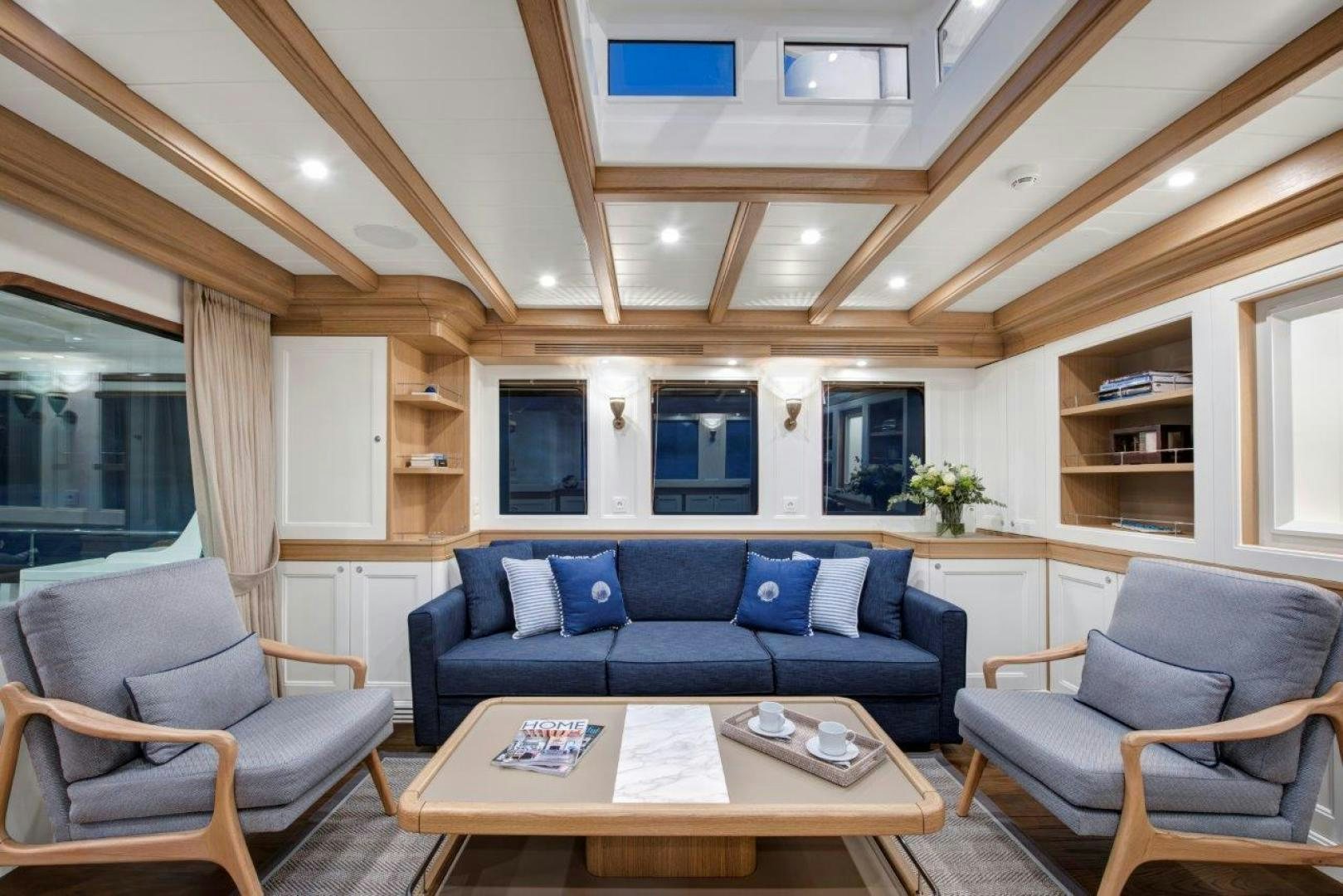 a living room with a blue couch and a wood table aboard MAGNOLIA ONE Yacht for Sale