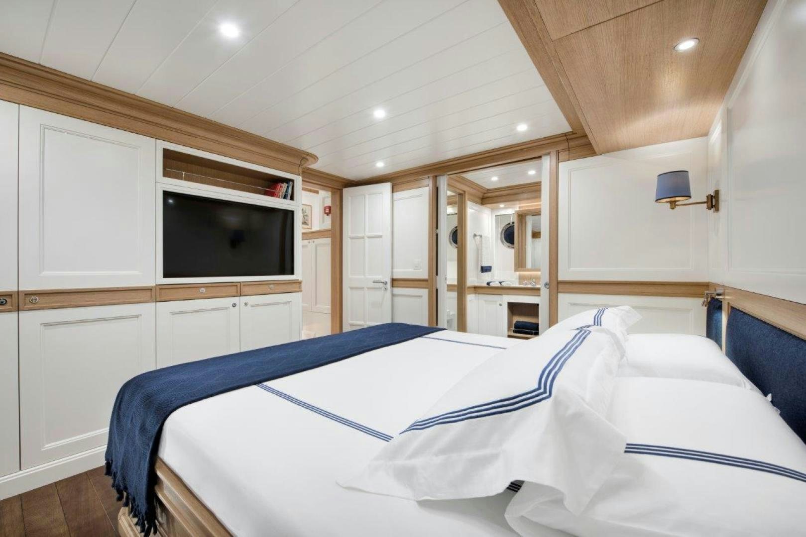 a bedroom with a bed and a television aboard MAGNOLIA ONE Yacht for Sale