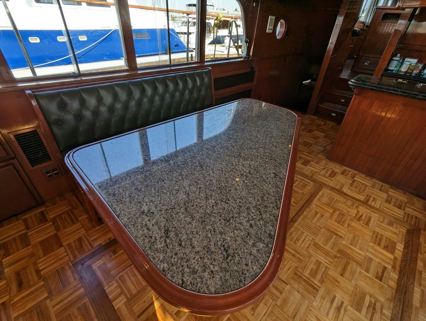 a large round table with a glass top and wood floor aboard ISABELLA Yacht for Sale