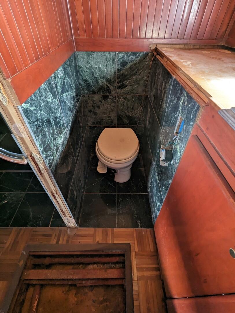 a bathroom with a toilet and a wooden cabinet aboard ISABELLA Yacht for Sale