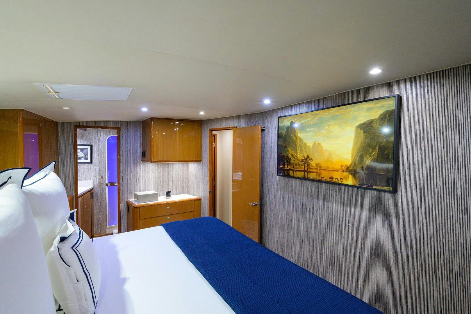 a bedroom with a painting on the wall aboard VAGRANT Yacht for Sale