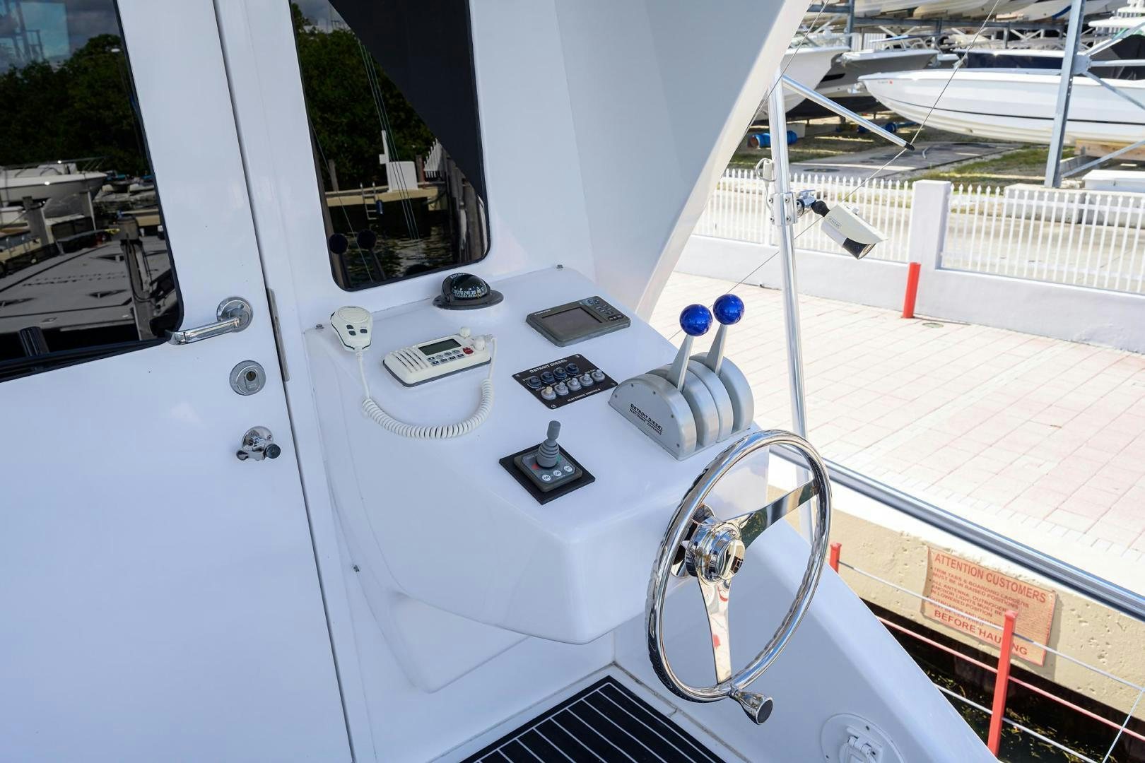 a white boat with a steering wheel aboard VAGRANT Yacht for Sale