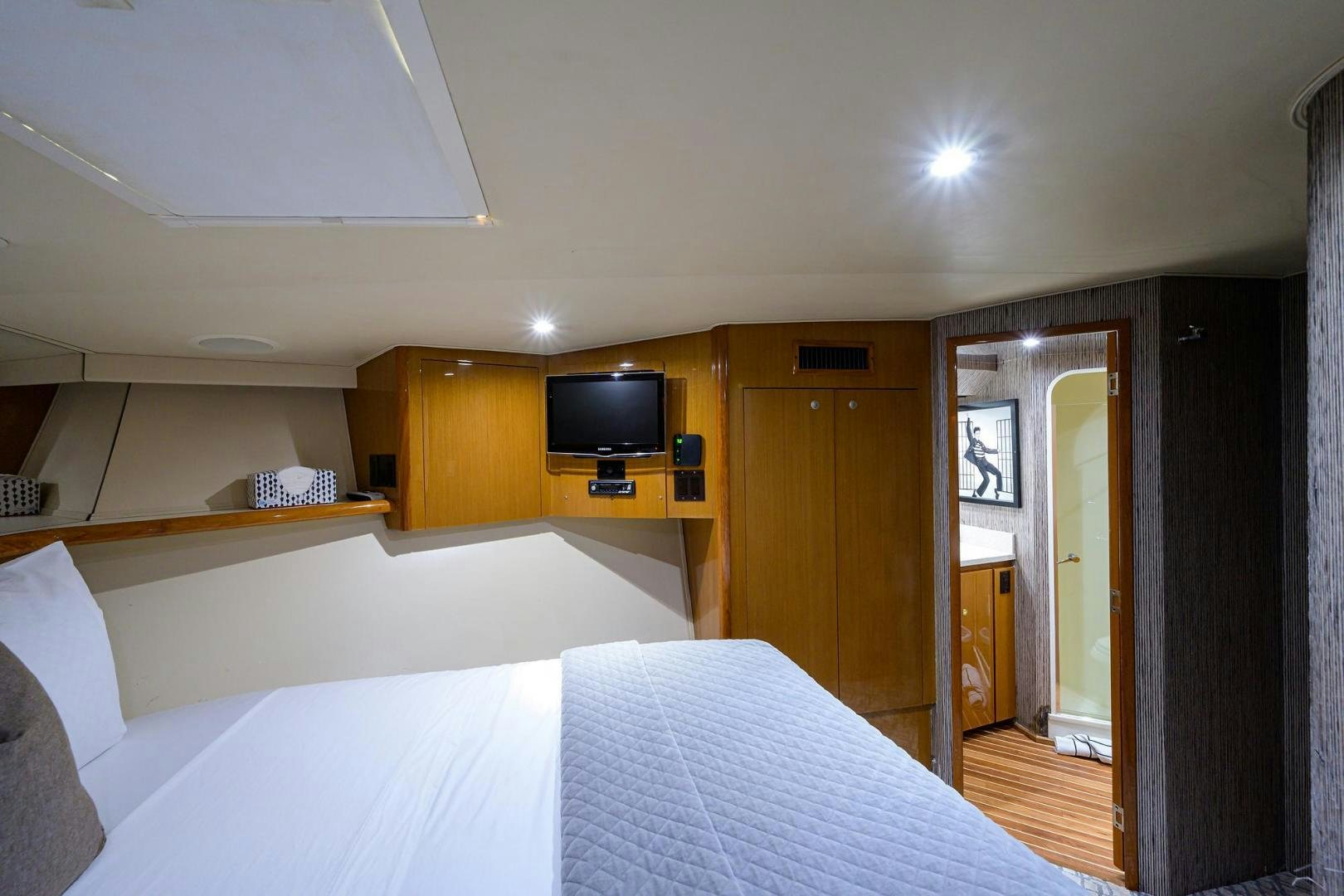 a bedroom with a bed and a tv on the wall aboard VAGRANT Yacht for Sale
