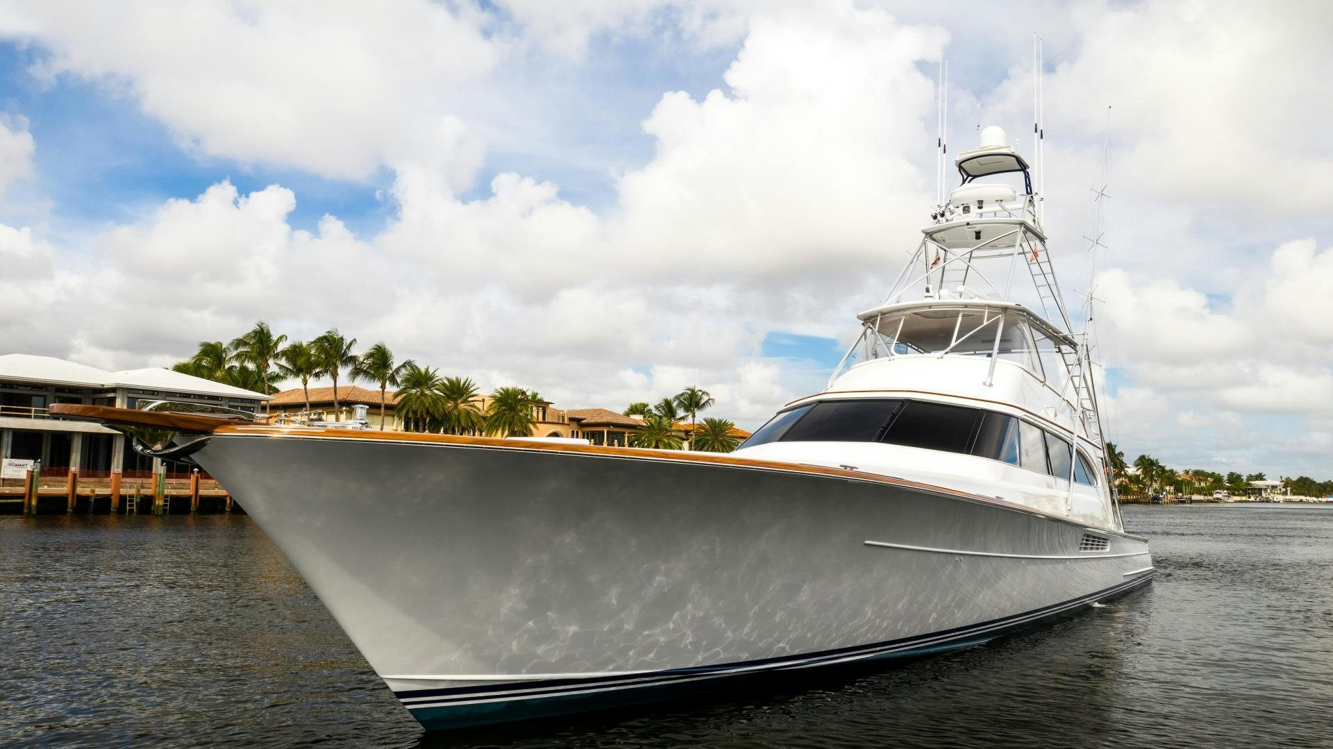 a white yacht docked at a dock aboard TANGAROA Yacht for Sale