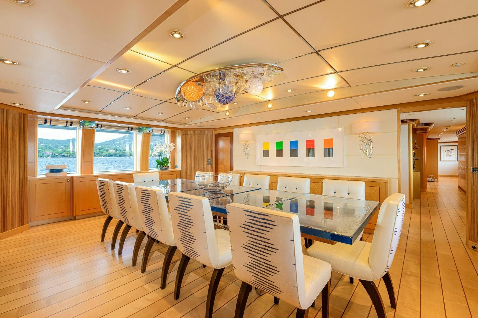 a large room with chairs and a table with a chandelier aboard VICTORIA DEL MAR Yacht for Sale