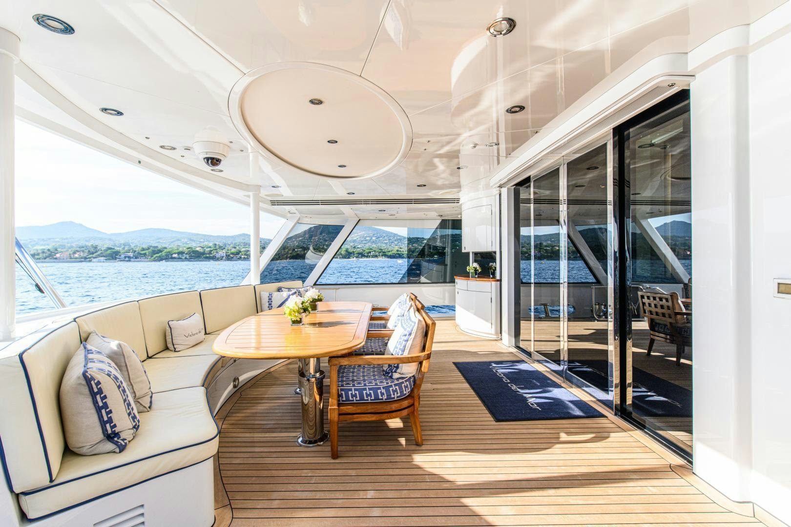 a living room with a large glass door and a view of the ocean aboard VICTORIA DEL MAR Yacht for Sale