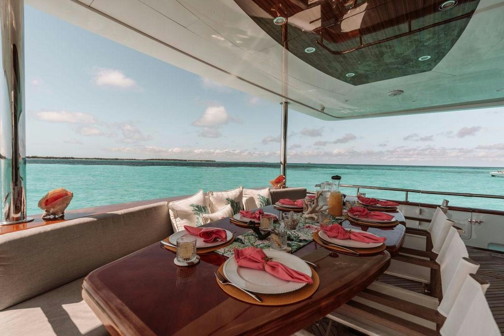 a table with plates and food on it by the ocean aboard BEACHFRONT Yacht for Sale
