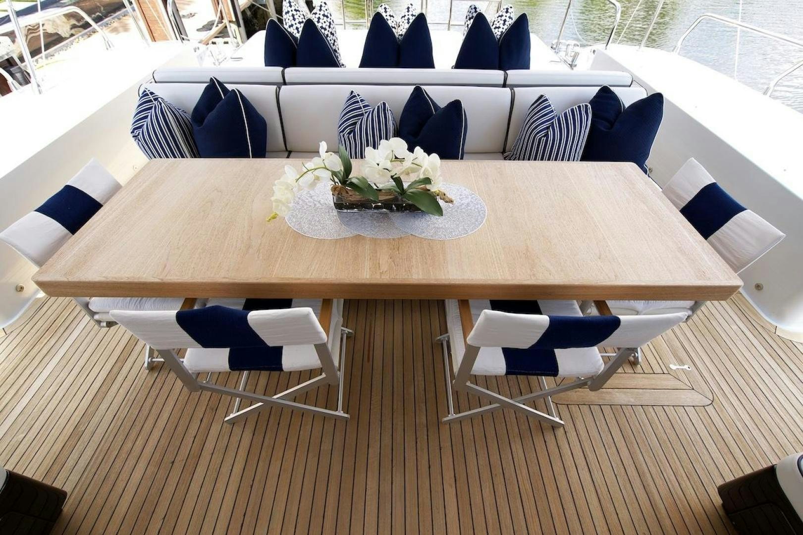 a table with chairs and a vase of flowers on it aboard U WISH Yacht for Sale