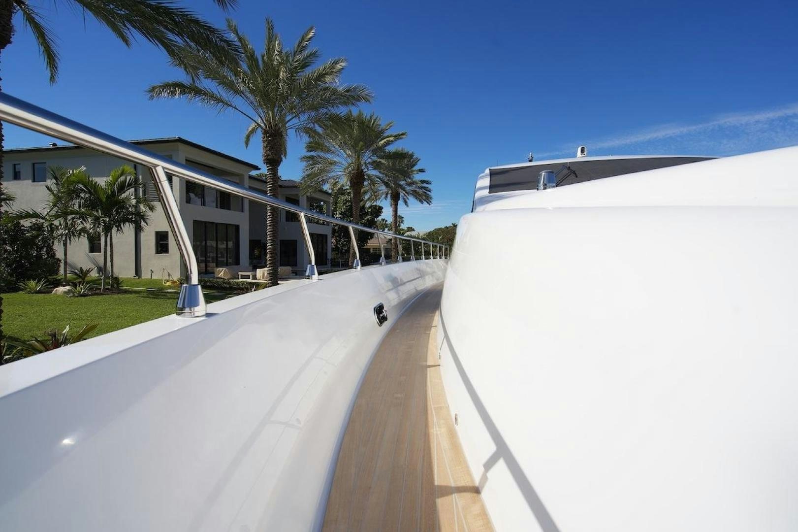 a road with palm trees and a building on the side aboard U WISH Yacht for Sale