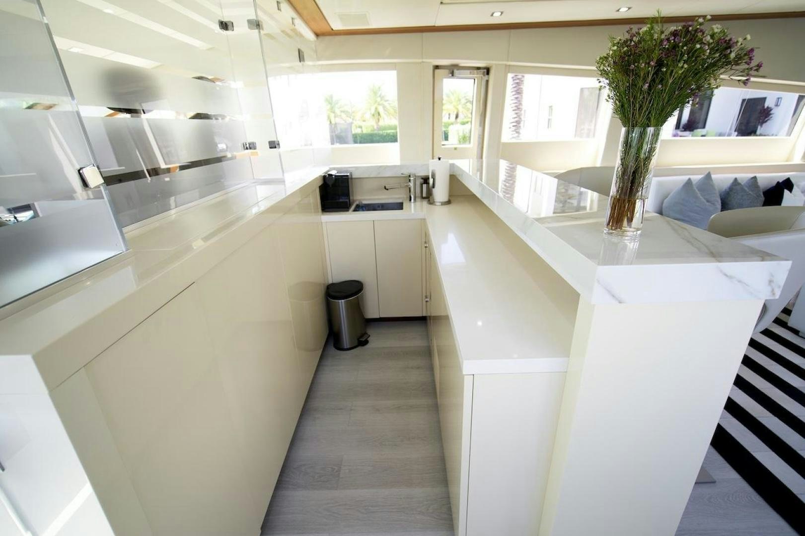 a large kitchen with white cabinets aboard U WISH Yacht for Sale