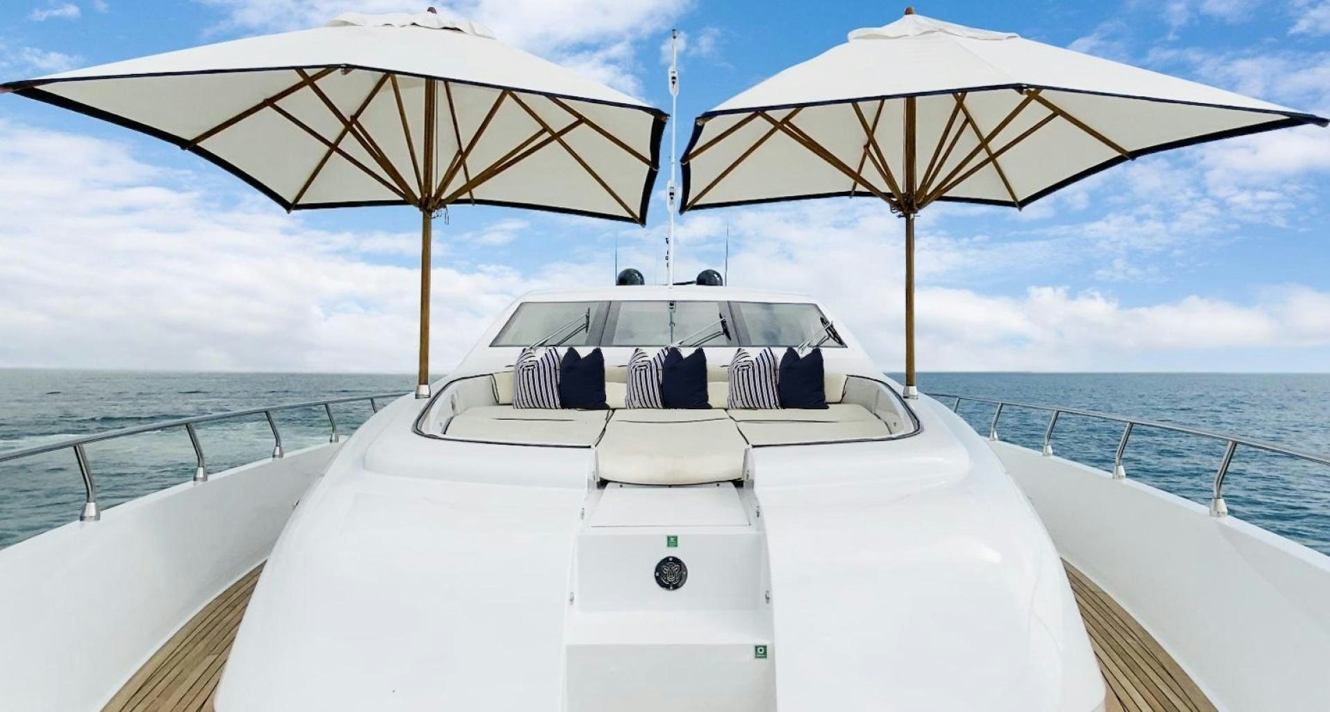 a boat with white pillows and umbrellas on a sunny day aboard U WISH Yacht for Sale