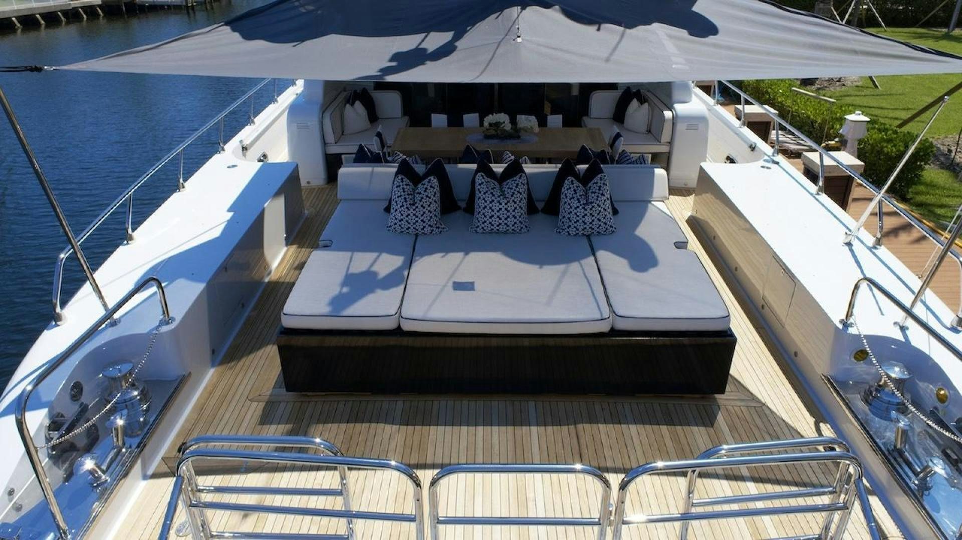 a deck with chairs and tables on it aboard U WISH Yacht for Sale