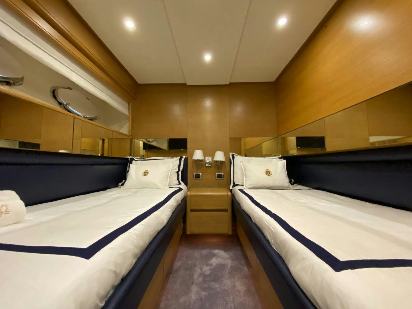 a room with beds and a mirror aboard MOKI Yacht for Sale