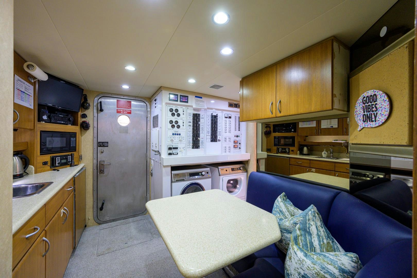 a living room with a couch and a kitchen aboard SUPERSTAR Yacht for Sale