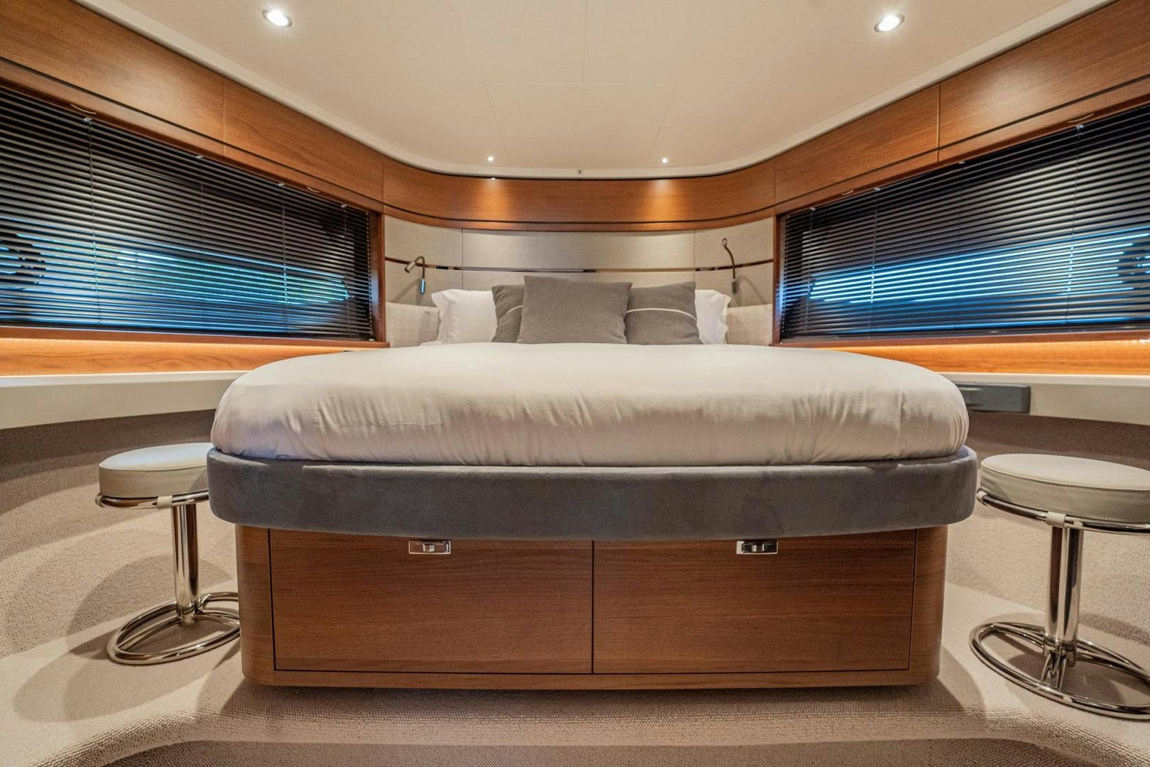 a bed with a desk and a window aboard COCOON Yacht for Sale