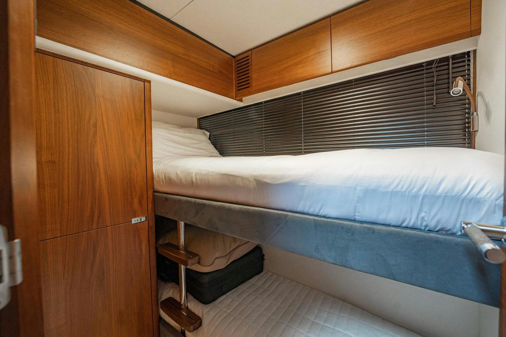 a bed with a wooden headboard aboard COCOON Yacht for Sale