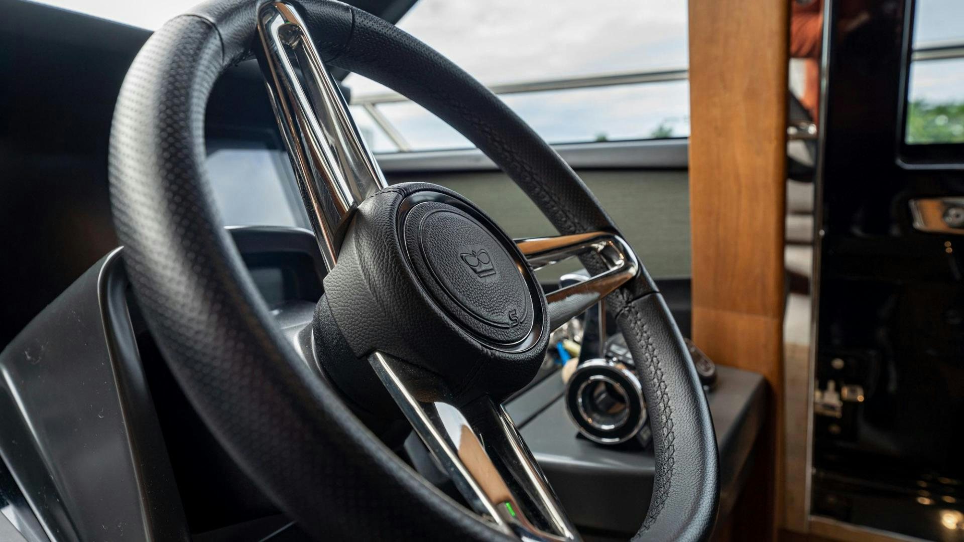 the steering wheel and dashboard of a car aboard COCOON Yacht for Sale