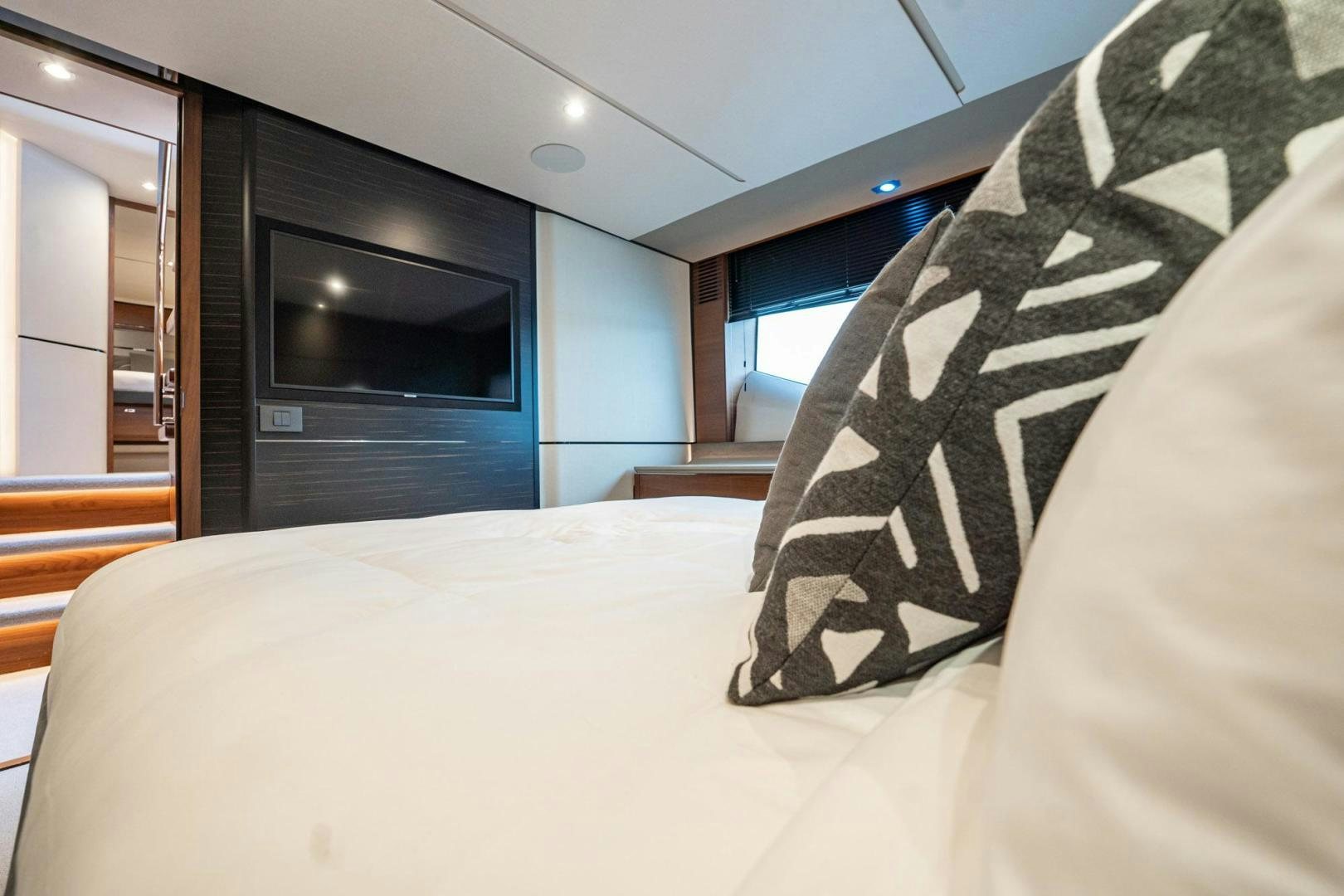 a bed with a white sheet and a black and white pillow aboard COCOON Yacht for Sale