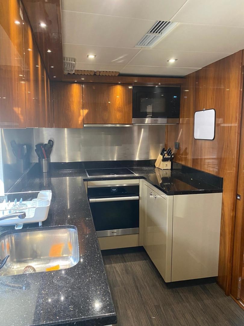 a kitchen with black counter tops aboard RIII Yacht for Sale