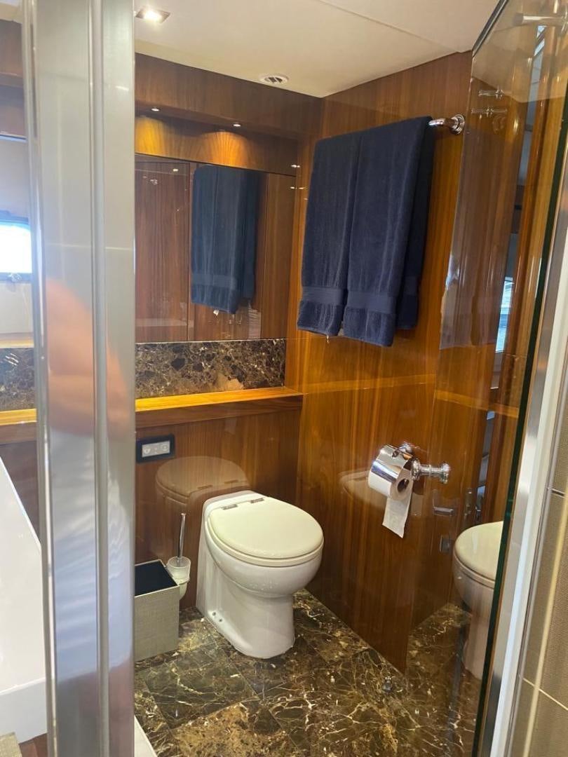 a bathroom with a toilet and a shower curtain aboard RIII Yacht for Sale