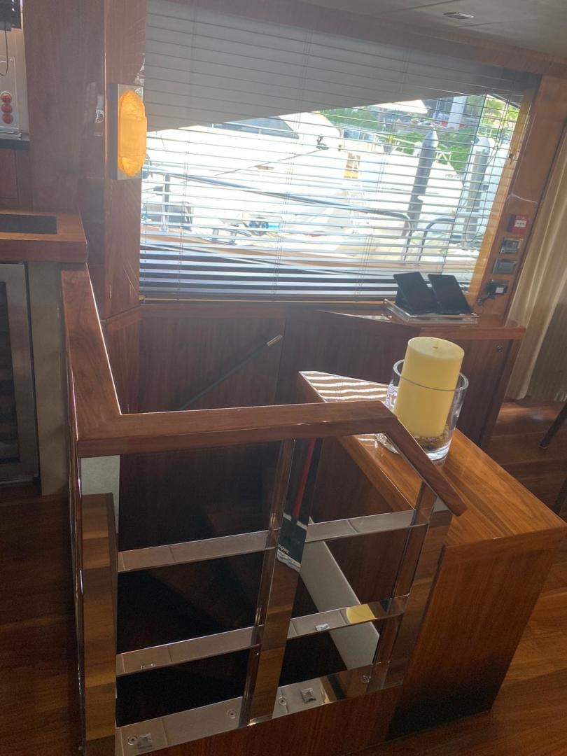 a window with a glass of yellow liquid and a laptop on a table aboard RIII Yacht for Sale