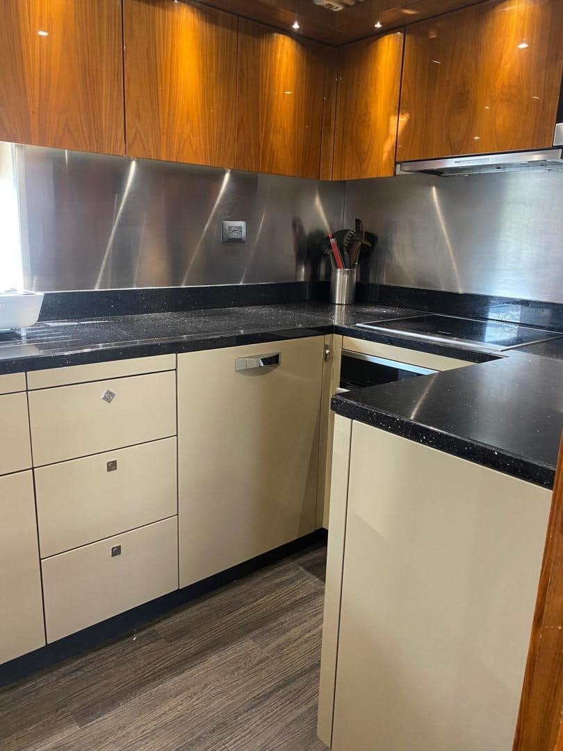 a kitchen with black counter tops aboard RIII Yacht for Sale