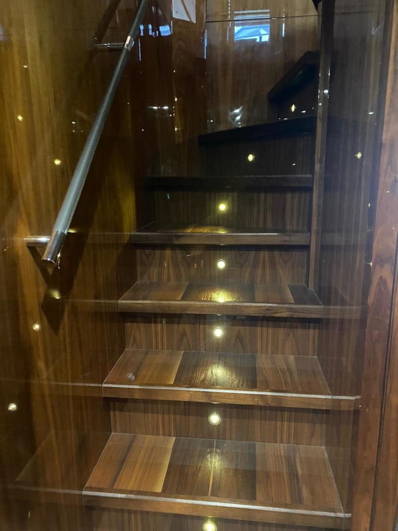 a wooden staircase with lights aboard RIII Yacht for Sale