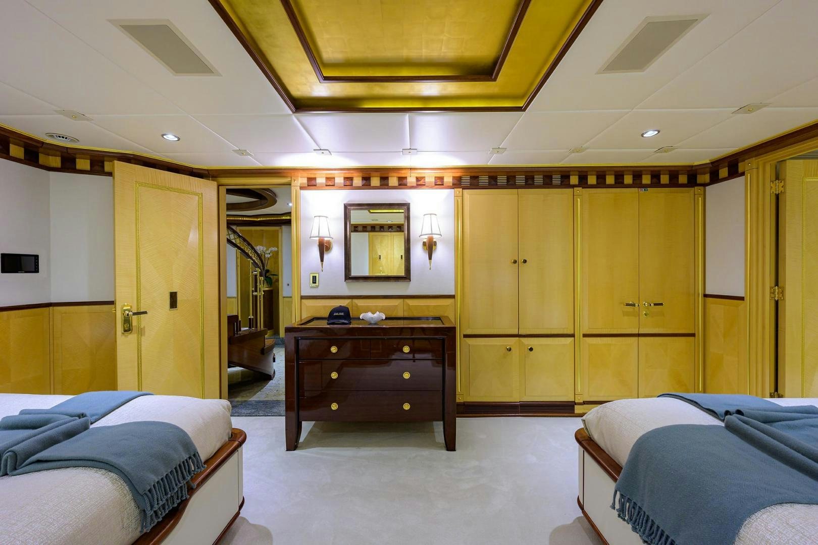 a room with a bed and a dresser aboard STARSHIP Yacht for Sale