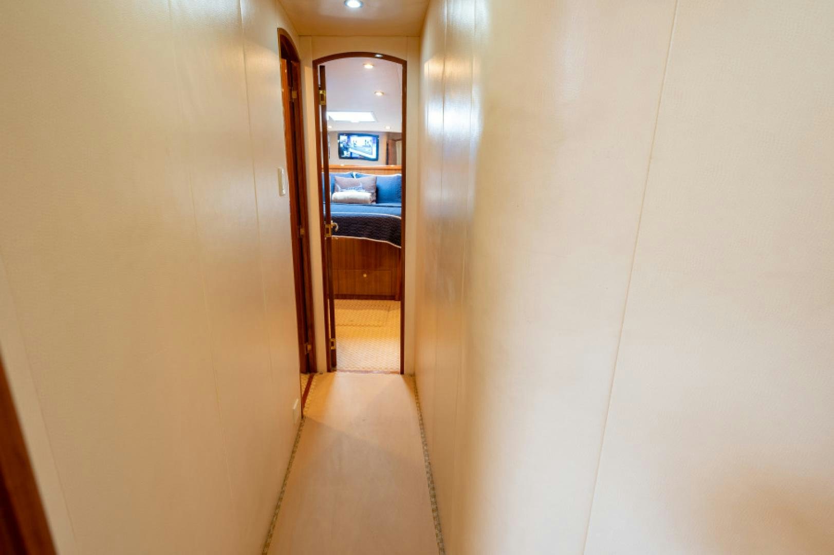 a hallway with a door and a bed in it aboard Bimini Babe Yacht for Sale