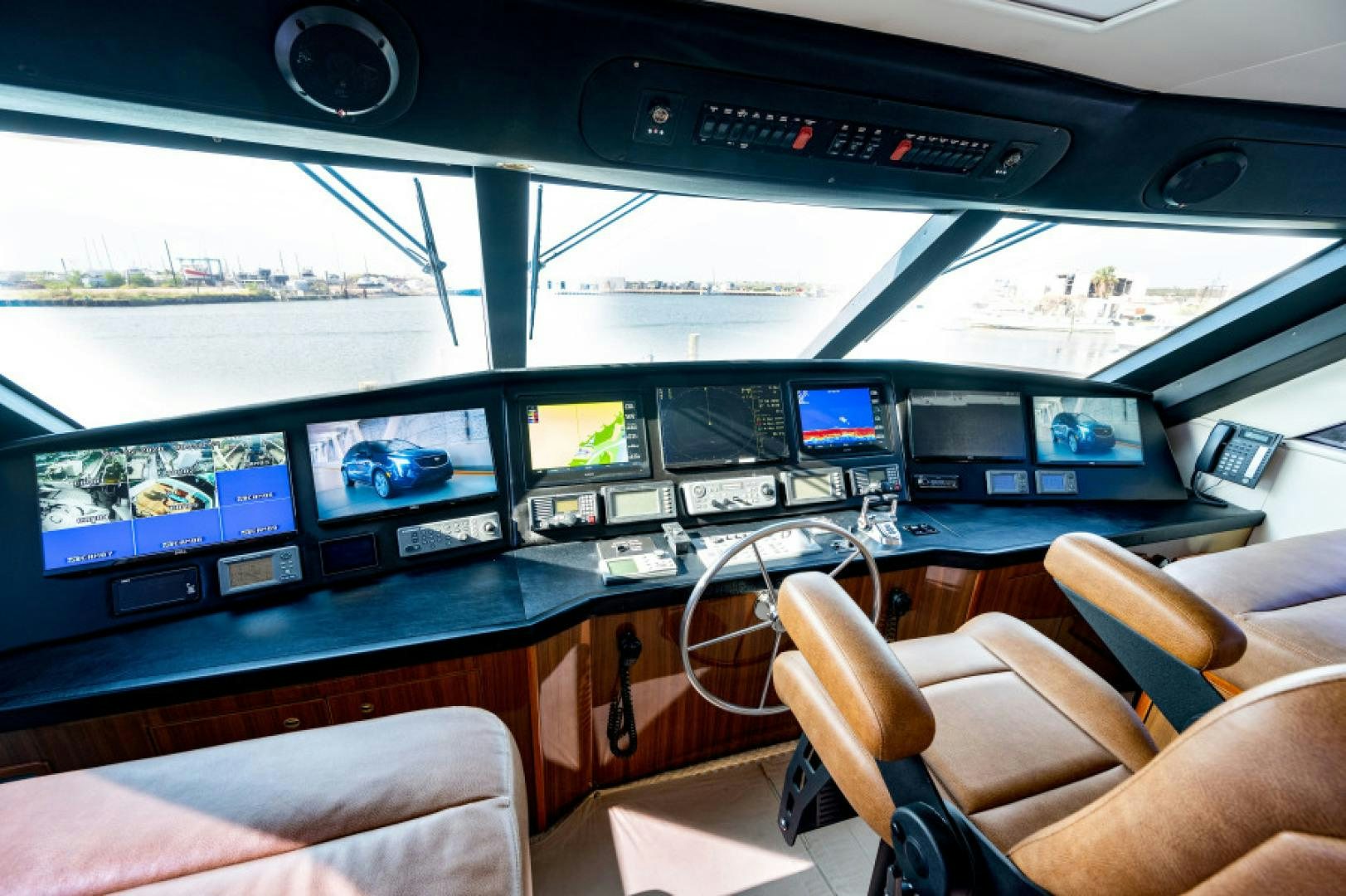 inside of a vehicle with many monitors and seats and seats aboard Bimini Babe Yacht for Sale