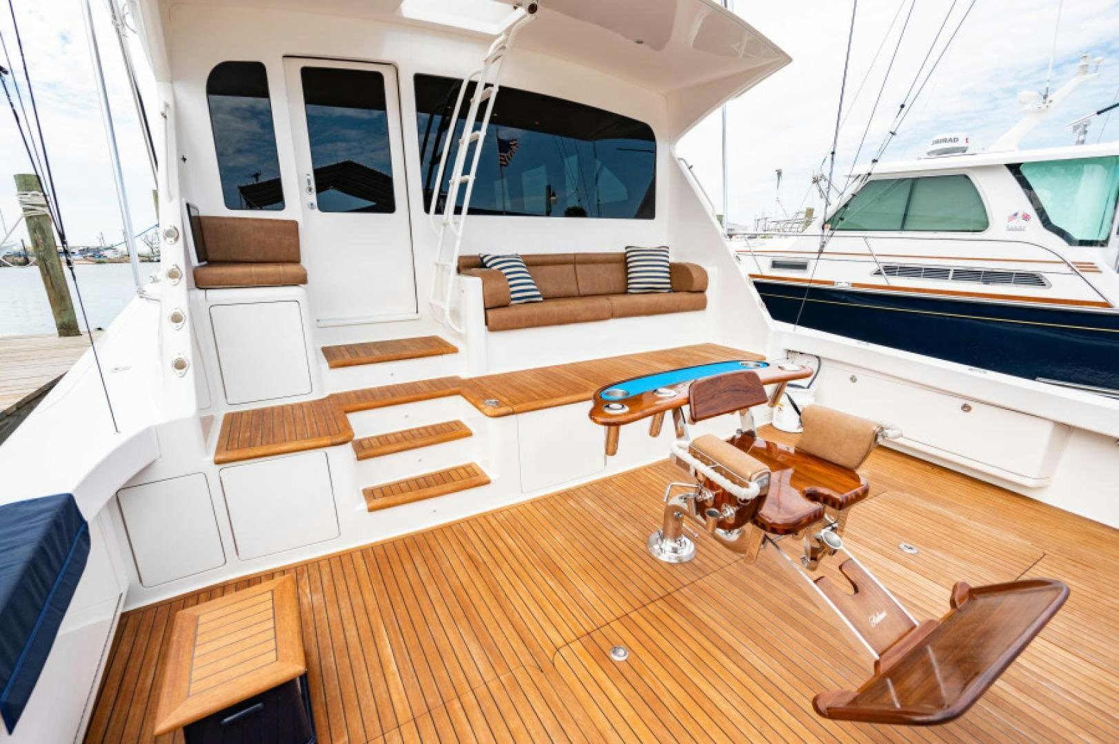 a boat with a deck and chairs aboard Bimini Babe Yacht for Sale