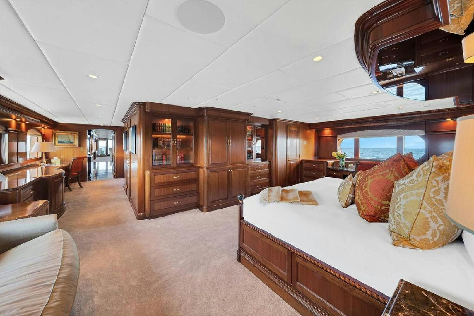 a bedroom with a bed and a wood cabinet aboard GRANDEUR Yacht for Sale