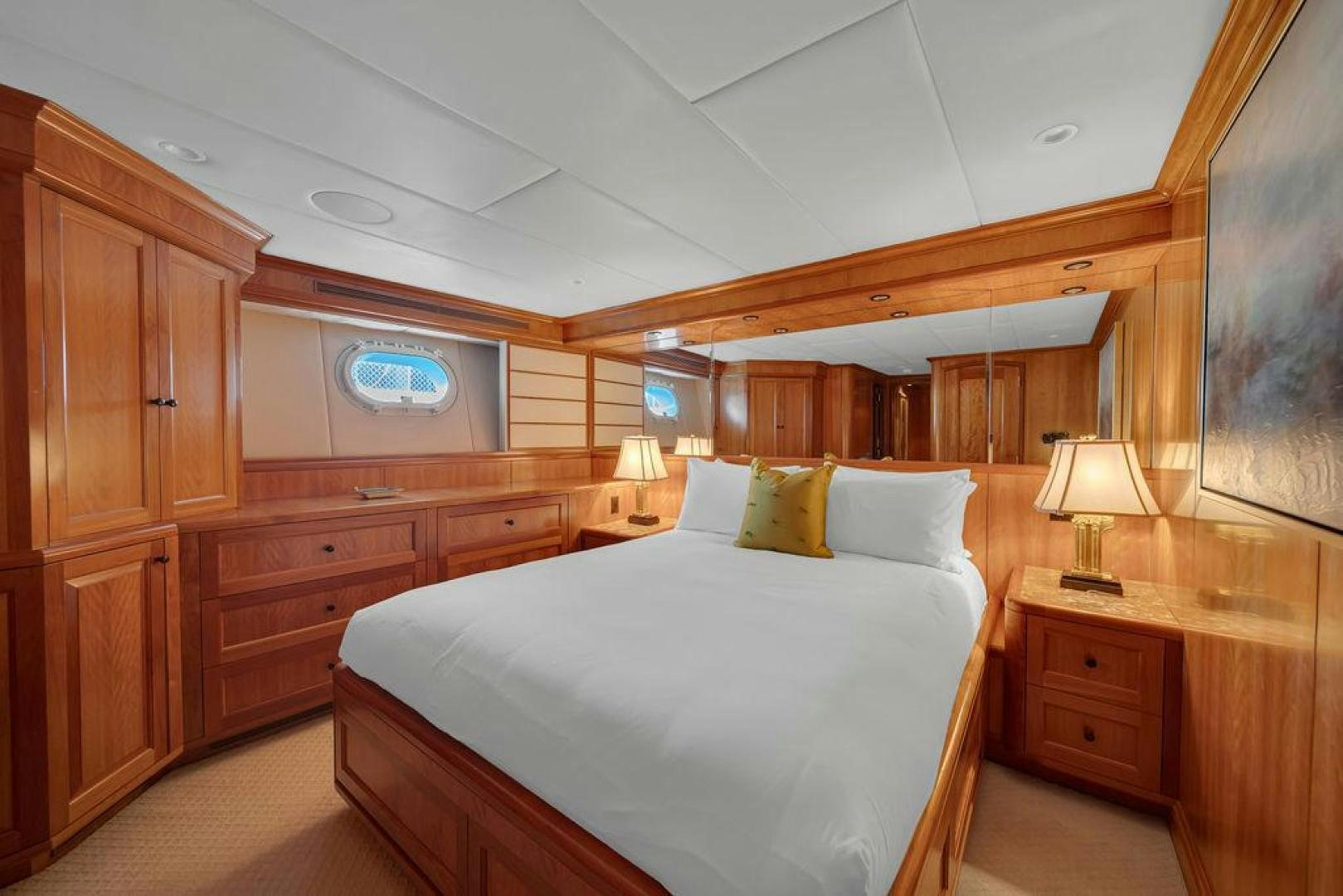 a bedroom with a bed and a dresser aboard GRANDEUR Yacht for Sale