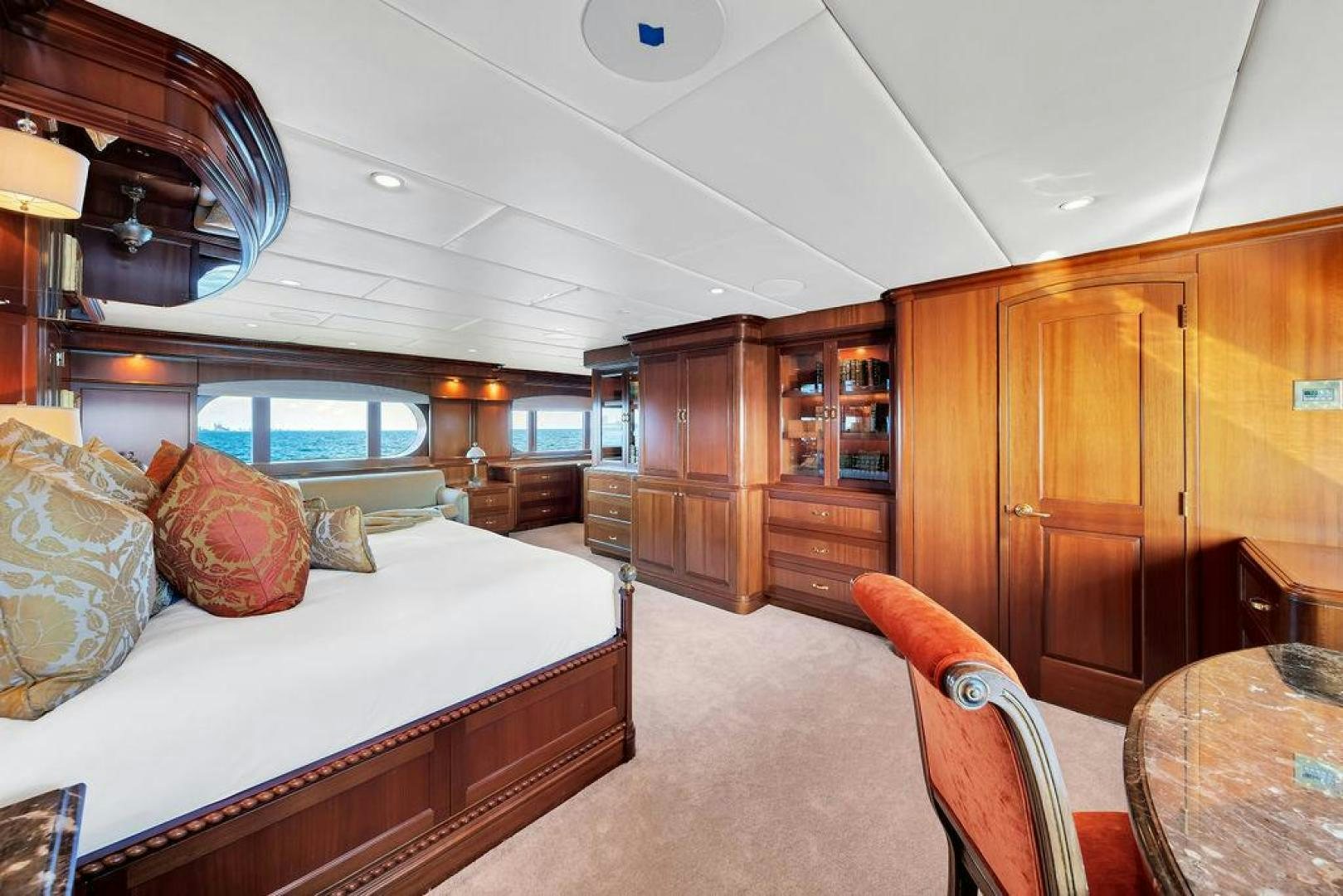 a bedroom with a bed and a wood cabinet aboard GRANDEUR Yacht for Sale