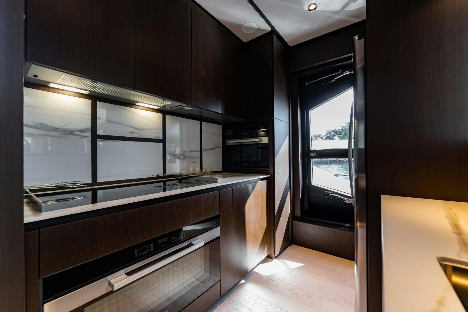 a kitchen with black cabinets aboard BESO Yacht for Sale