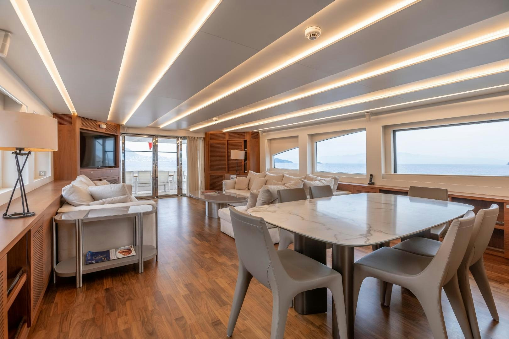 a large living room with a table and chairs aboard VICTORY Yacht for Sale