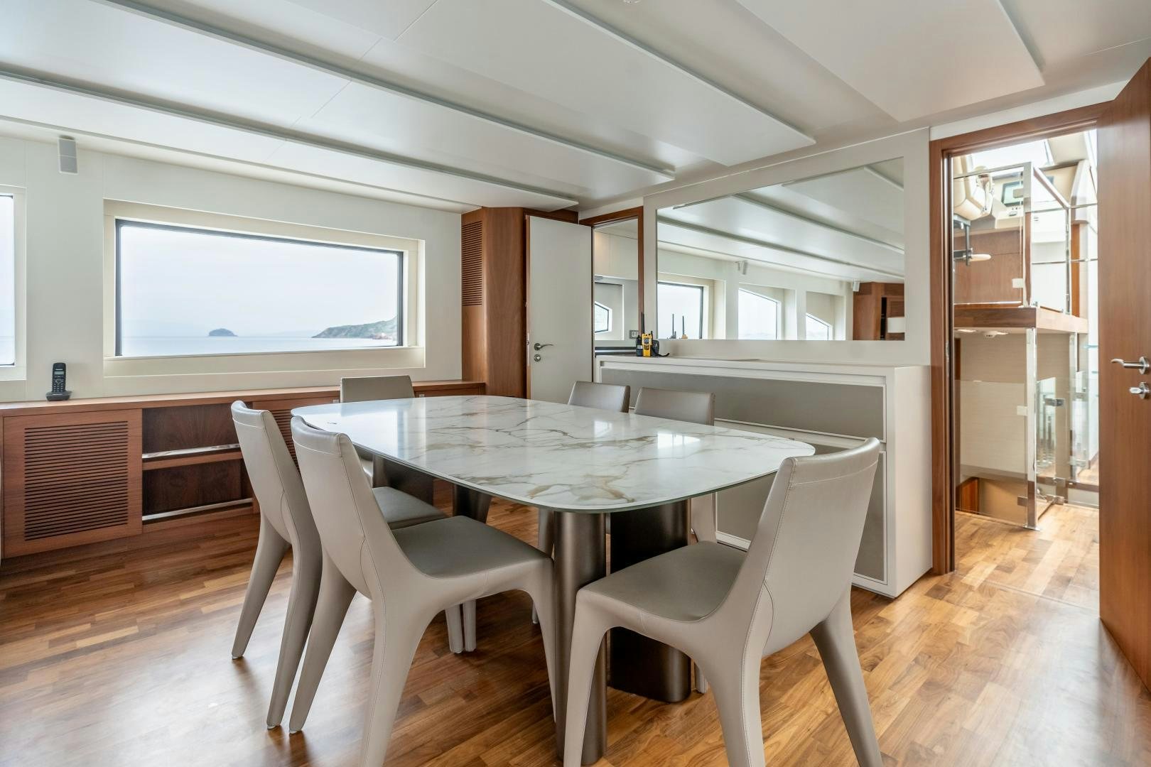 a dining table and chairs in a room with wood floors aboard VICTORY Yacht for Sale