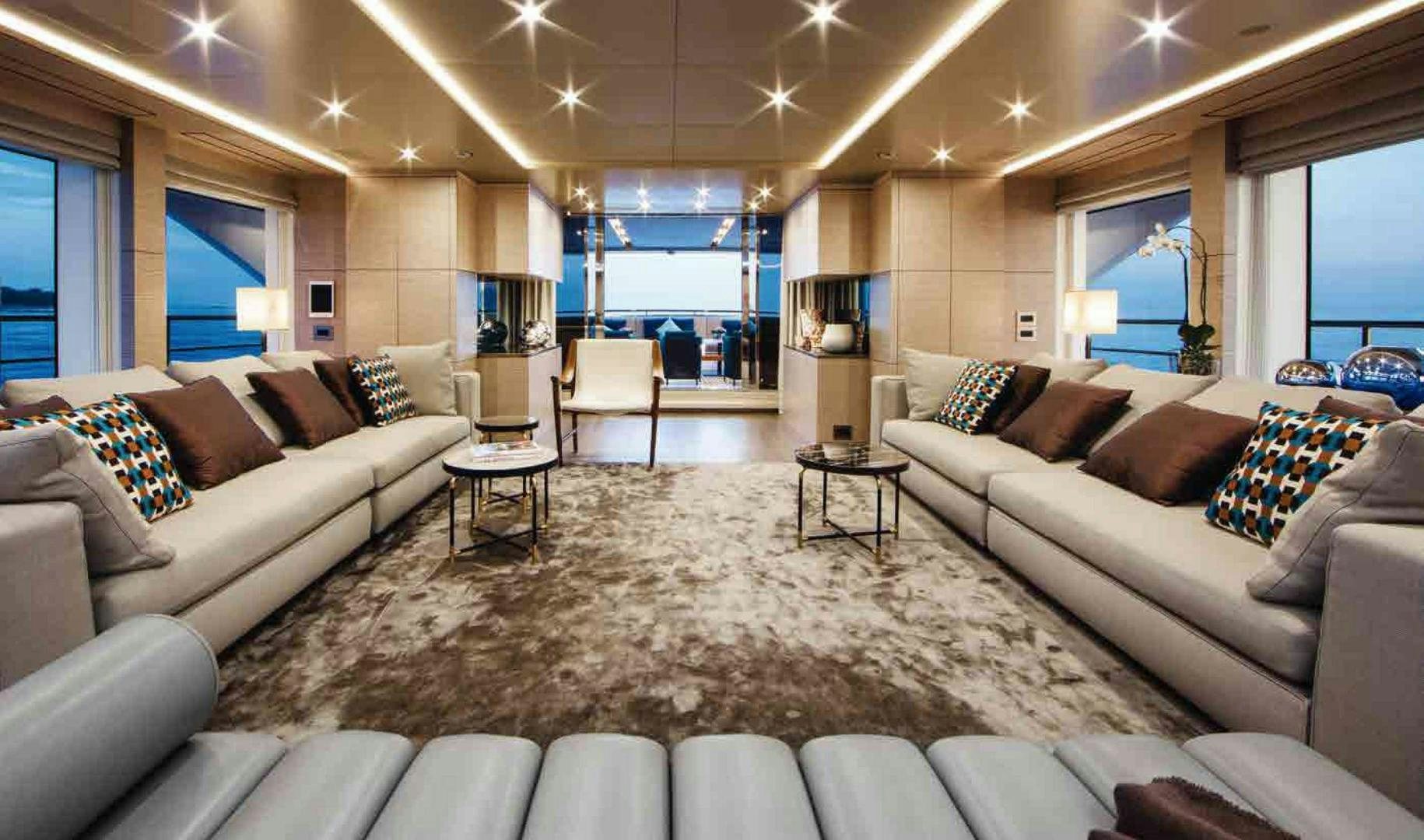 a living room with a large white couch and a large window aboard COFINA Yacht for Sale