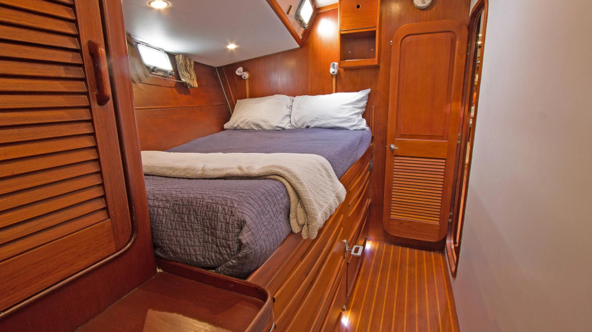 a bed with a wooden door aboard EAGLE'S NEST Yacht for Sale