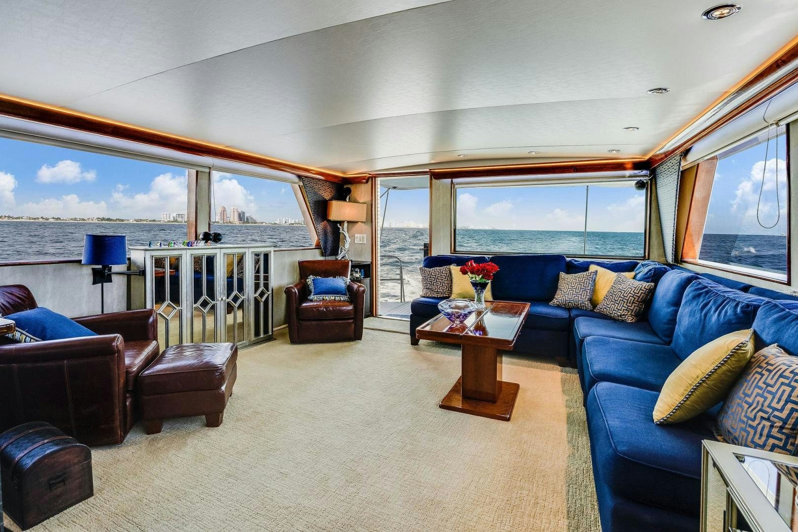 a living room with a blue couch and a large window aboard PEYTONS PLACE Yacht for Sale