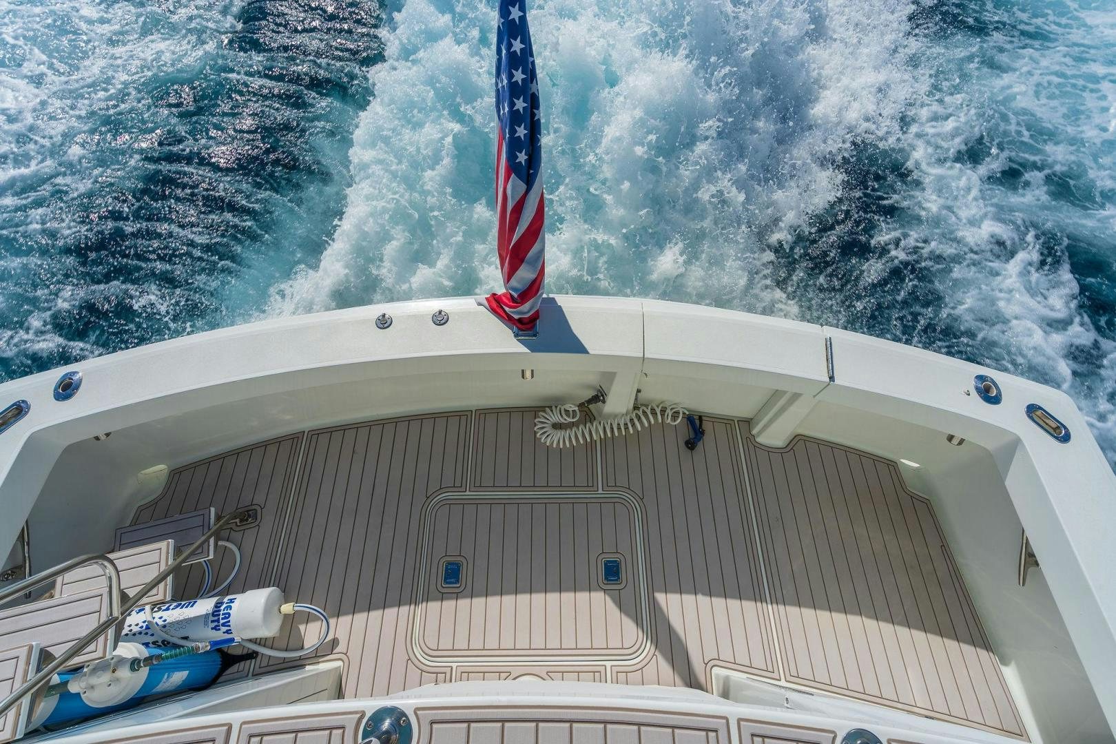 a boat with a flag on the front aboard PEYTONS PLACE Yacht for Sale