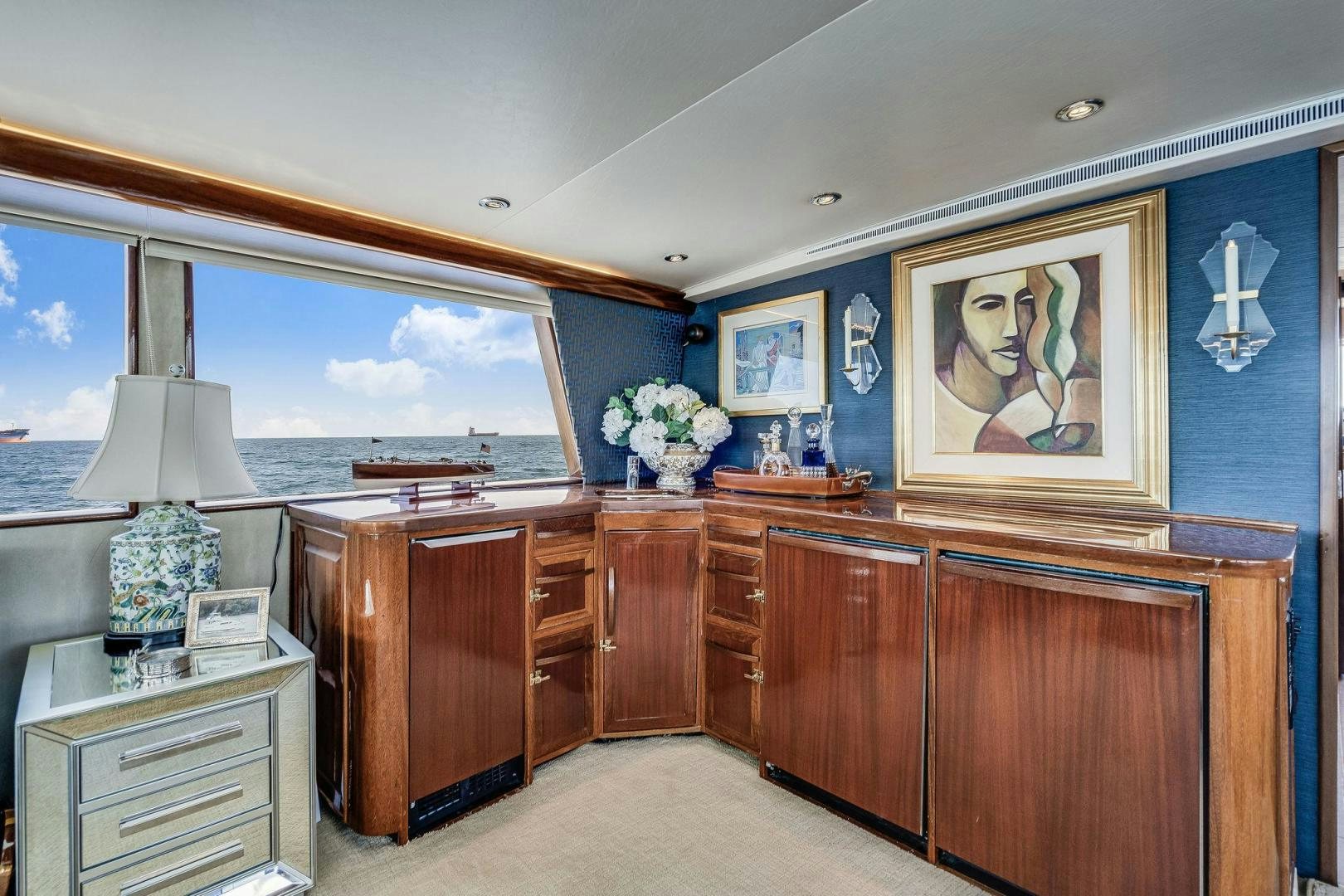 a room with a large window and a desk with a large painting aboard PEYTONS PLACE Yacht for Sale
