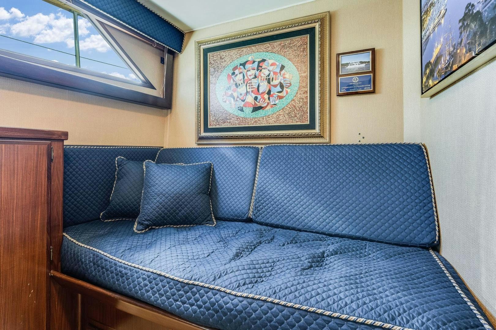a bed with a painting on the wall aboard PEYTONS PLACE Yacht for Sale