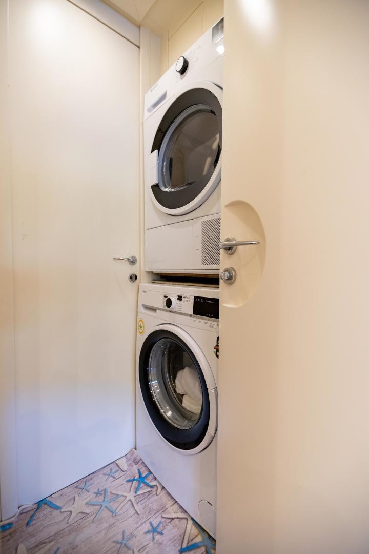 a white laundry room with washing machine aboard ALYSSA 1 Yacht for Sale