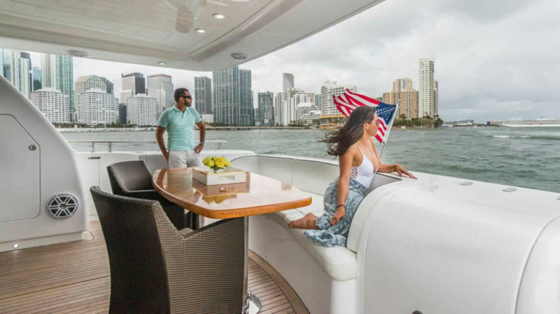 a man and woman sitting on a couch on a boat aboard NEXT Yacht for Sale