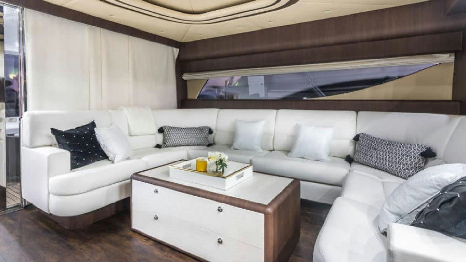 a white couch with pillows and a coffee table in a room aboard NEXT Yacht for Sale