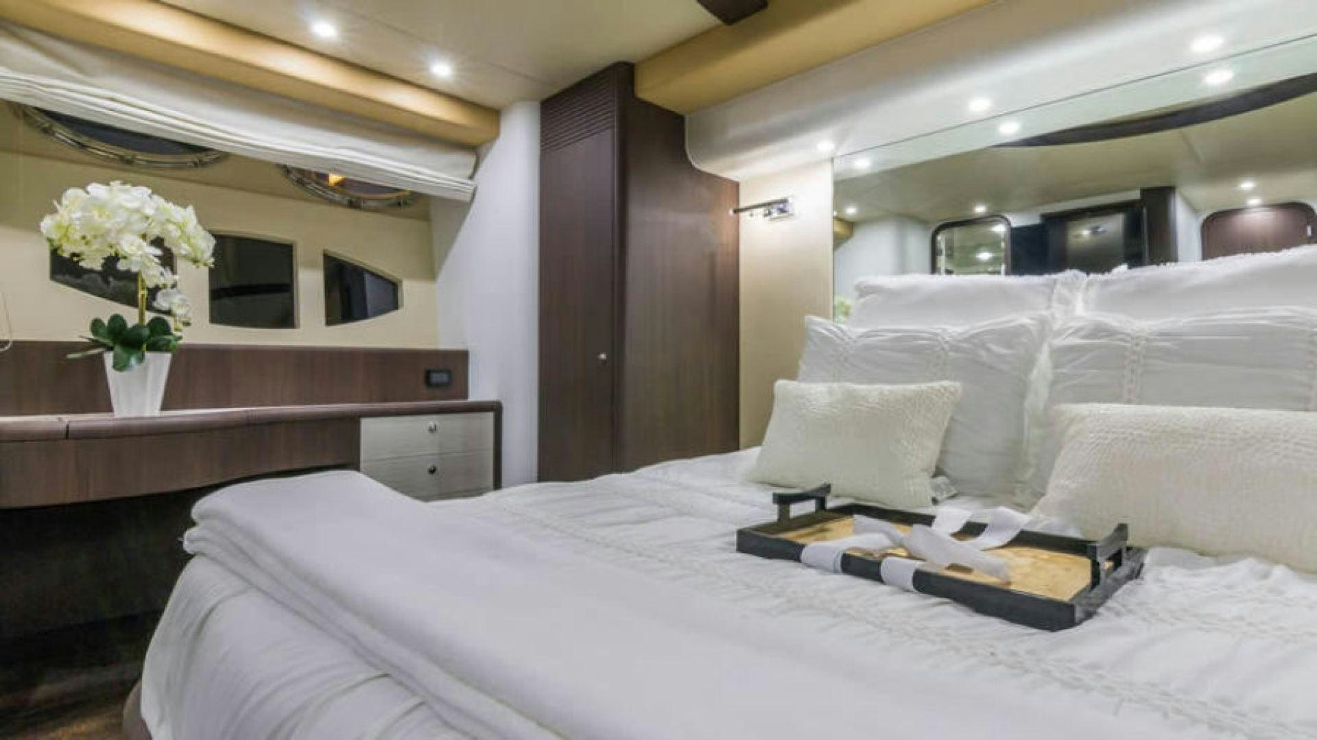 a bed with white sheets and pillows aboard NEXT Yacht for Sale