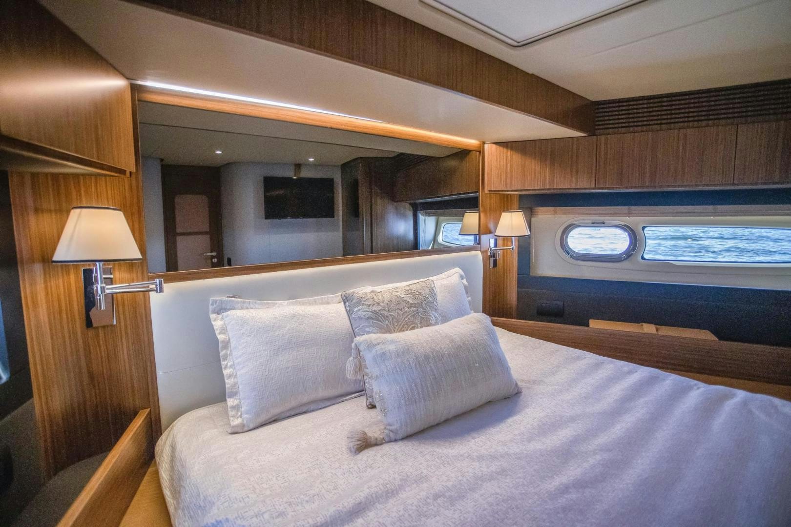 a bed with pillows and a window aboard ROY Yacht for Sale